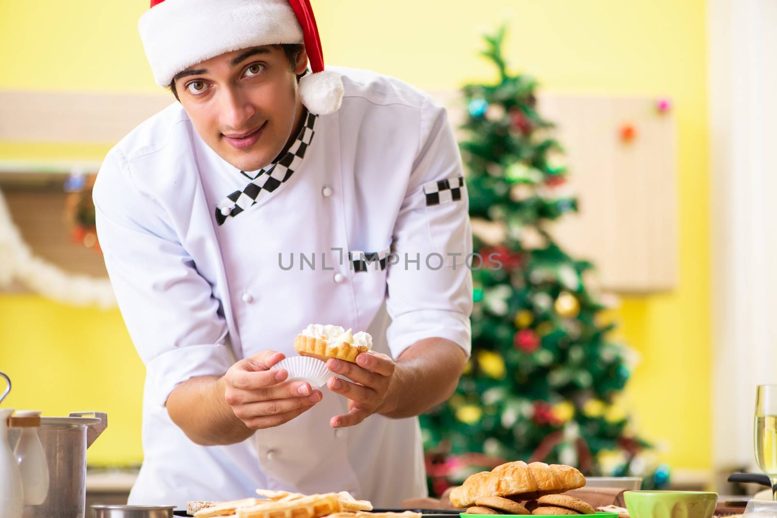 Young chef husband working in kitchen at Christmas eve 