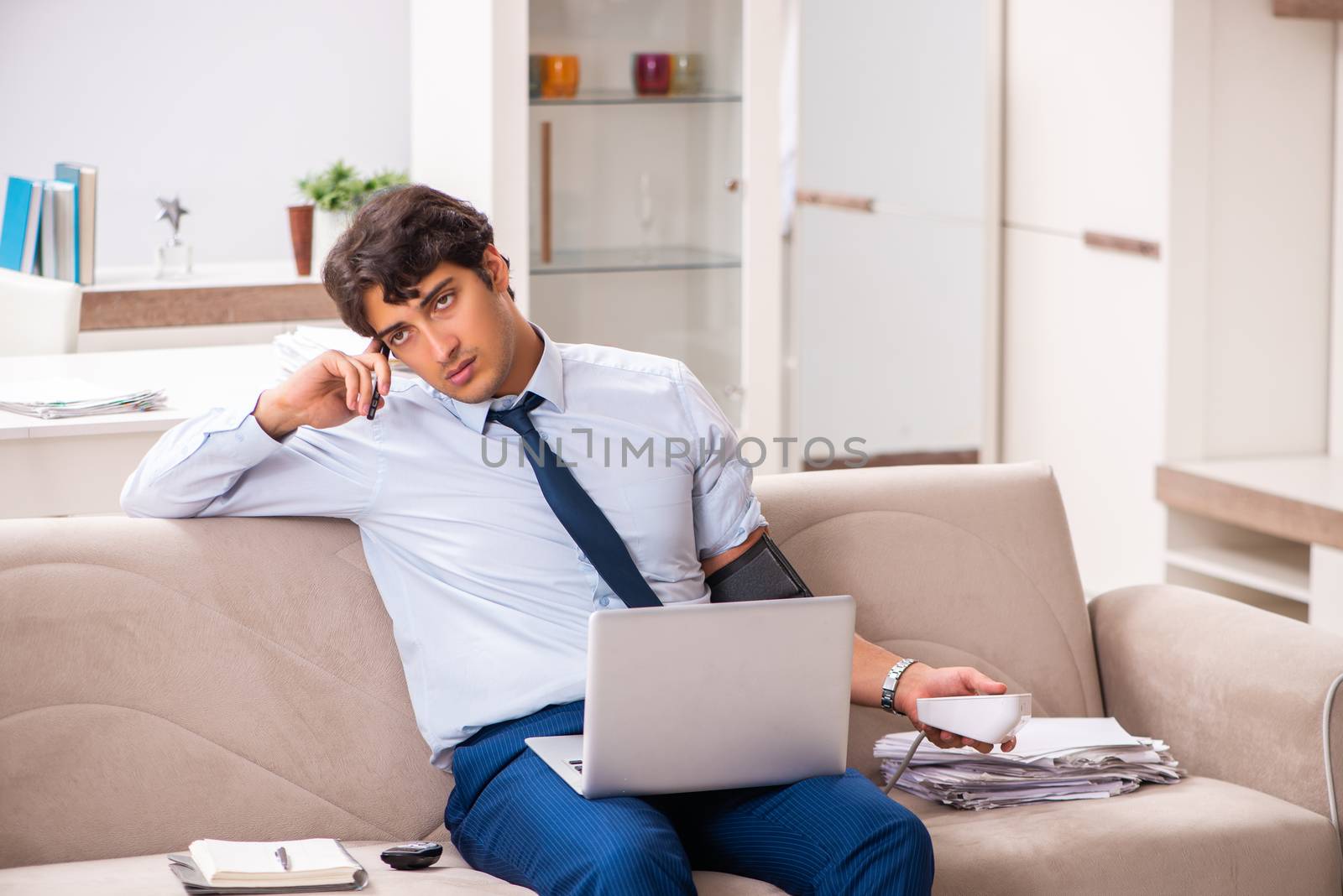 Man under stress measuring his blood pressure