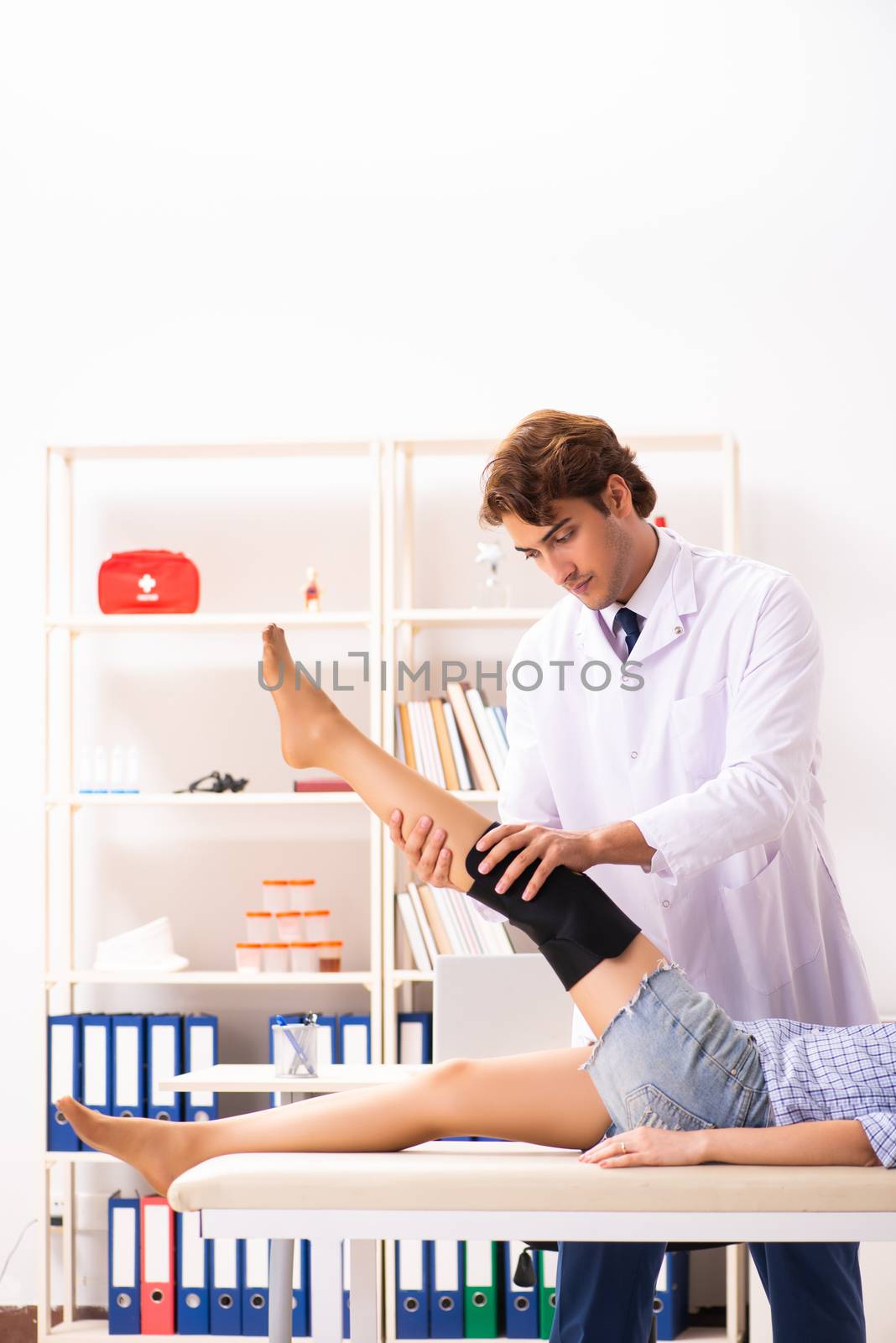 Young female patient visiting male doctor traumatologist  by Elnur