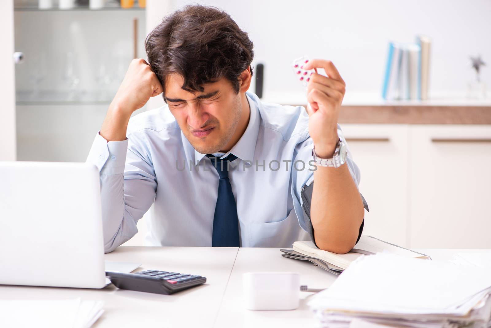 Man under stress measuring his blood pressure