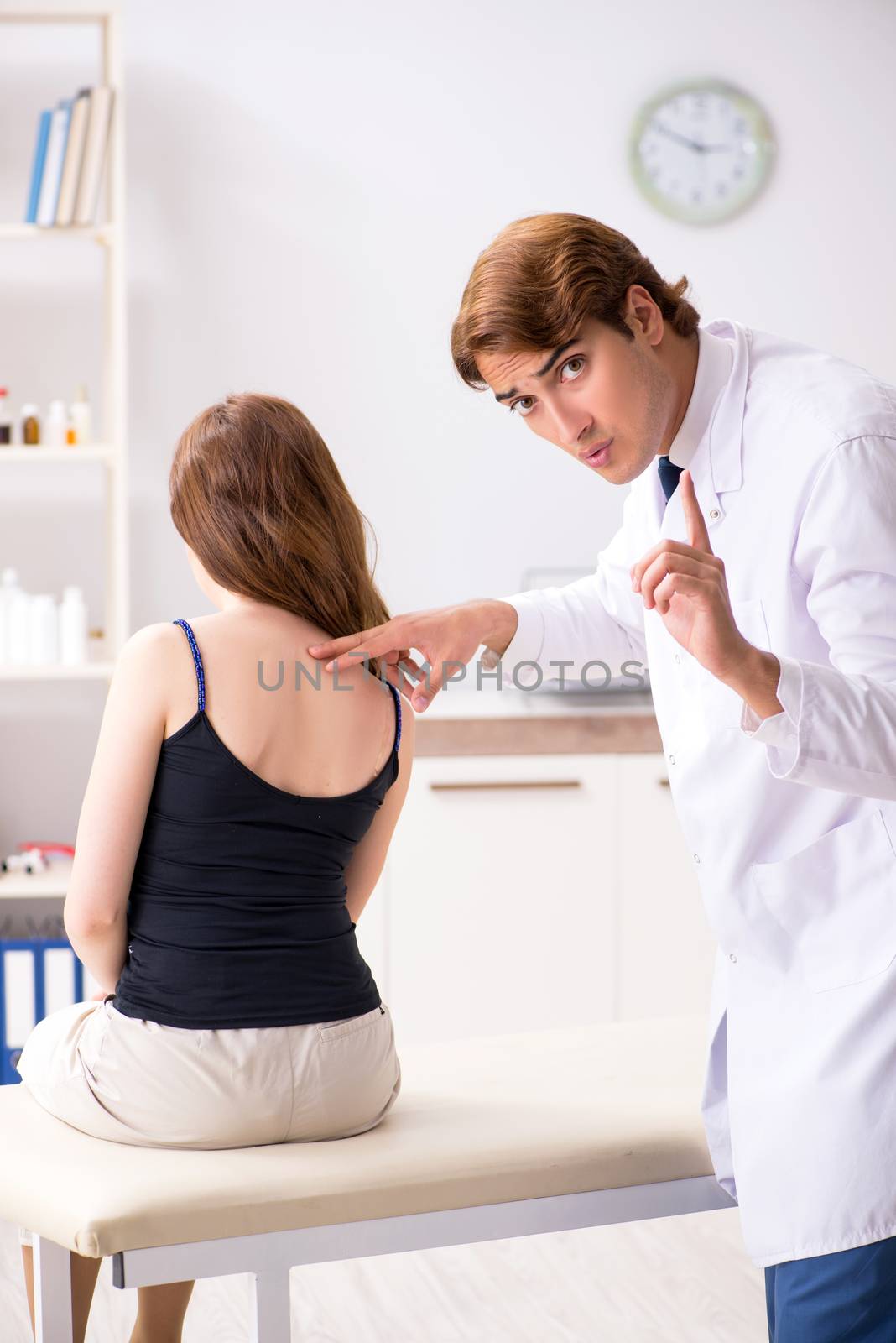 Female patient visiting young handsome doctor chiropractor 