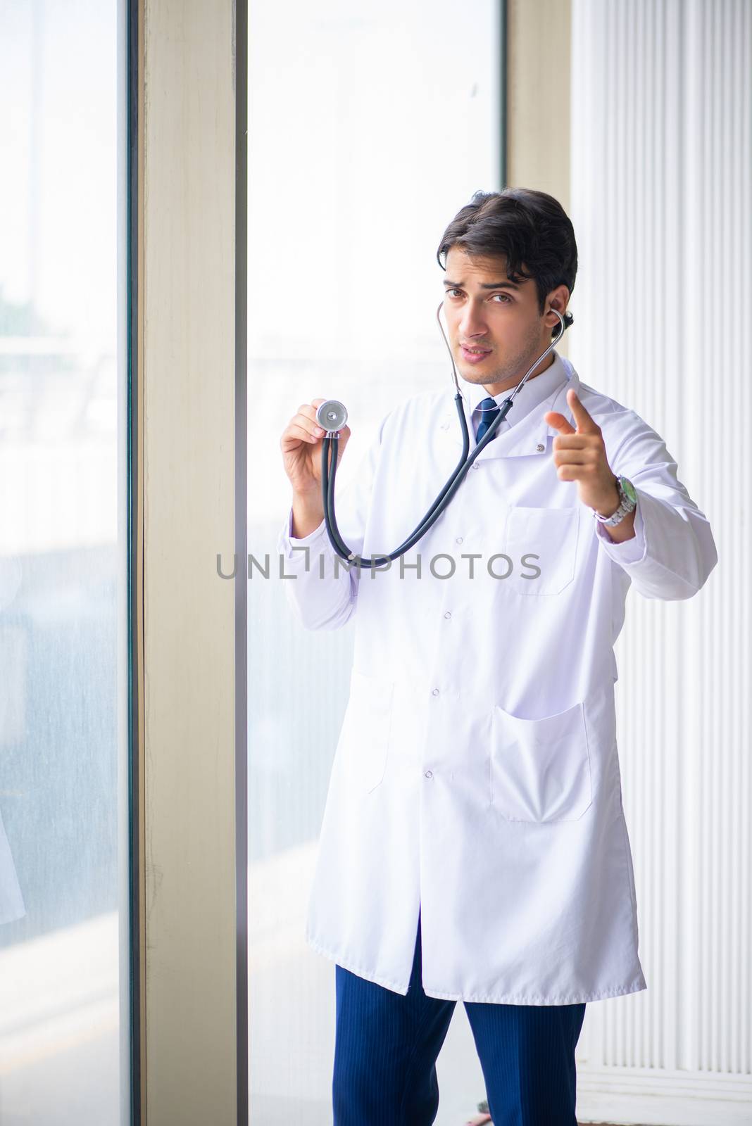 Young handsome doctor standing at the window  by Elnur