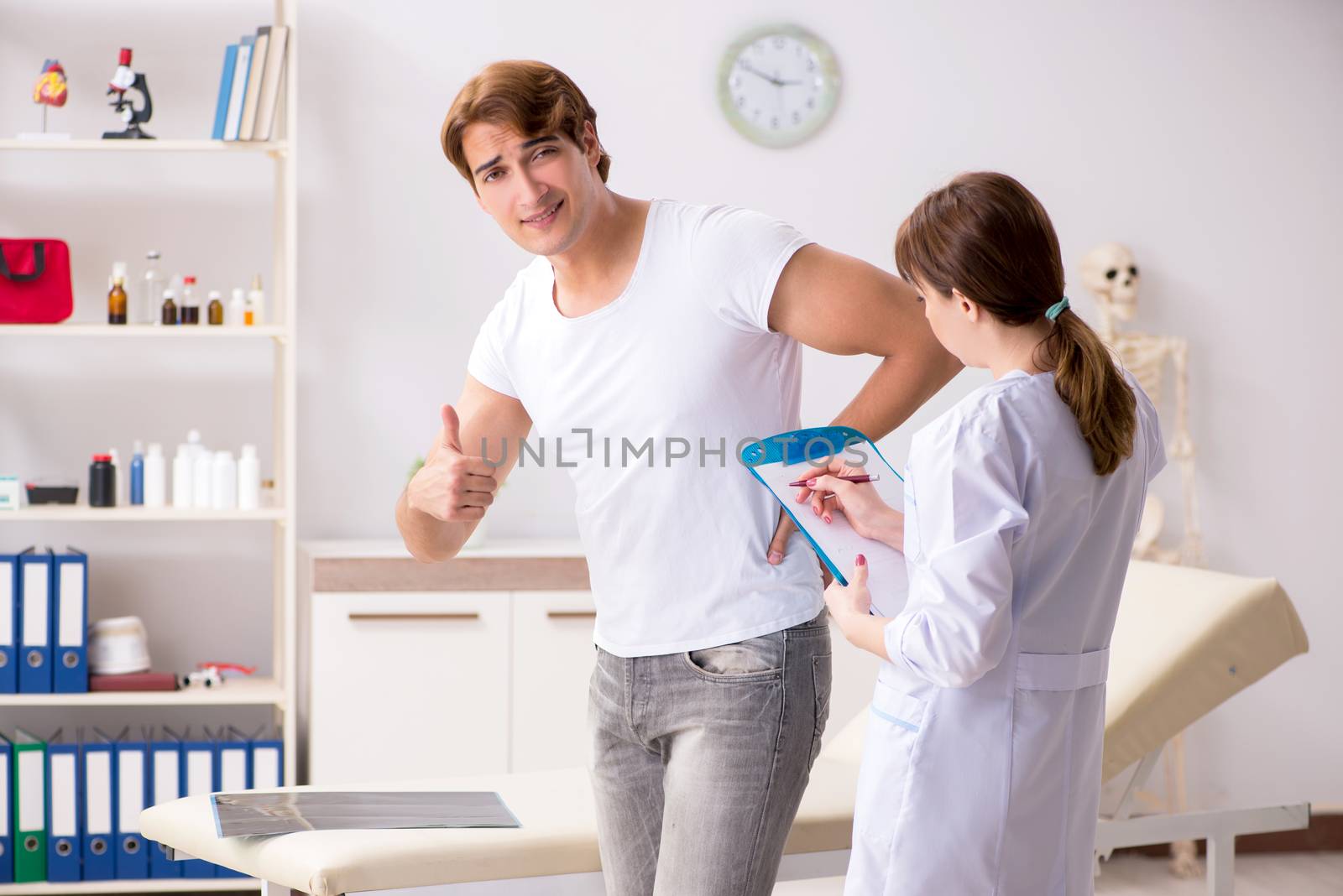 Male patient visiting young female doctor chiropractor 