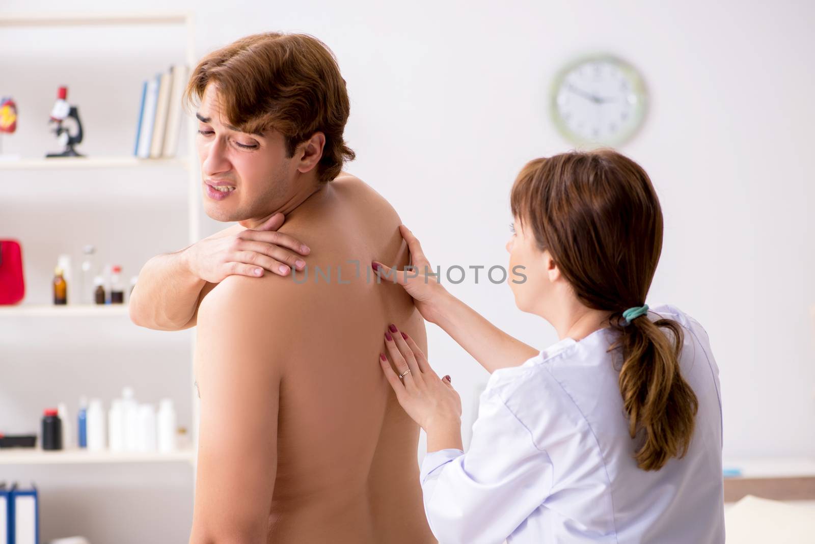 Young female doctor chiropractor massaging male patient