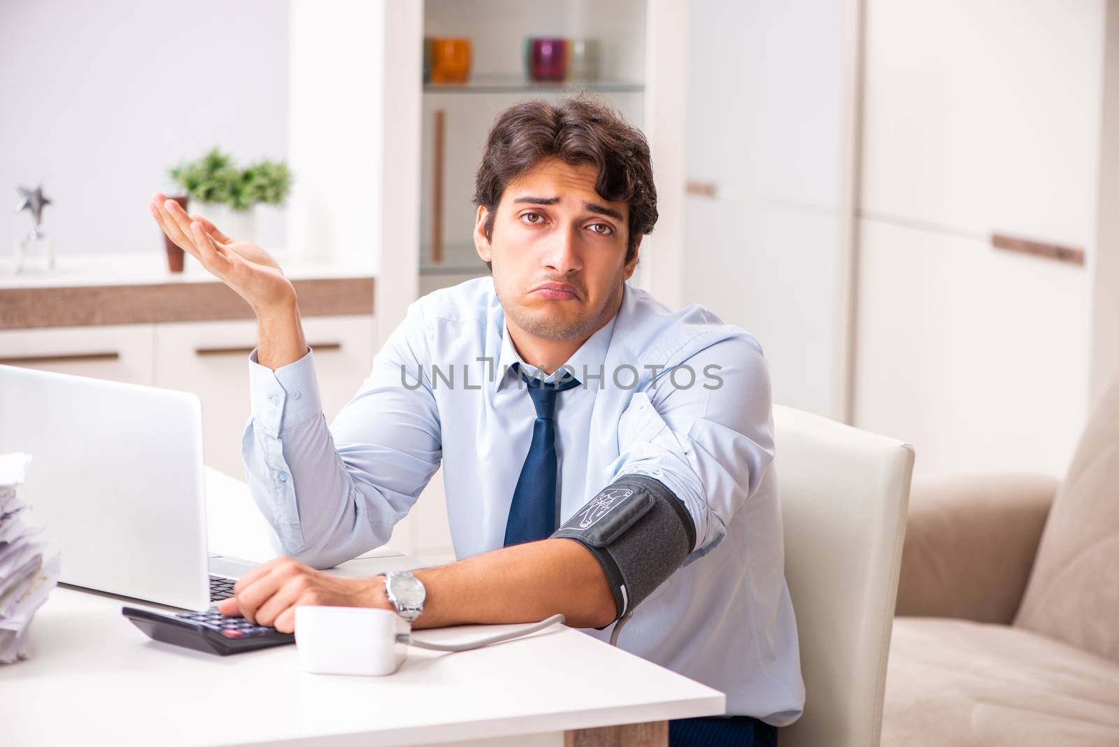 Man under stress measuring his blood pressure