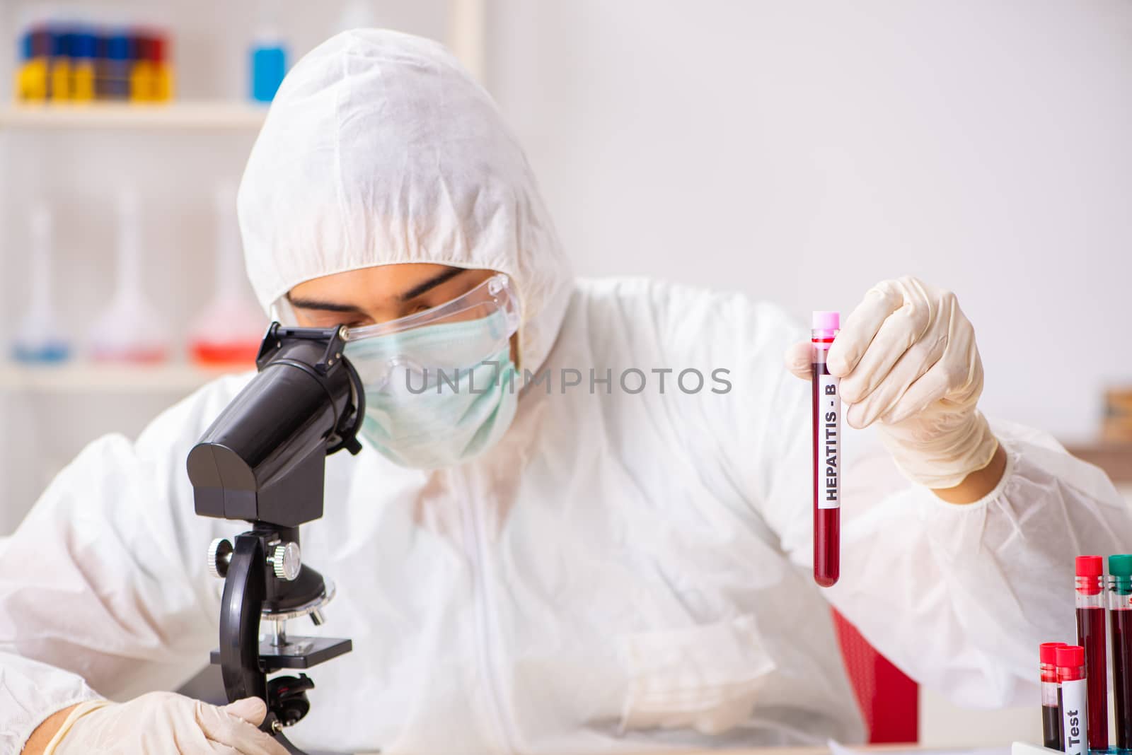 Young handsome lab assistant testing blood samples in hospital 