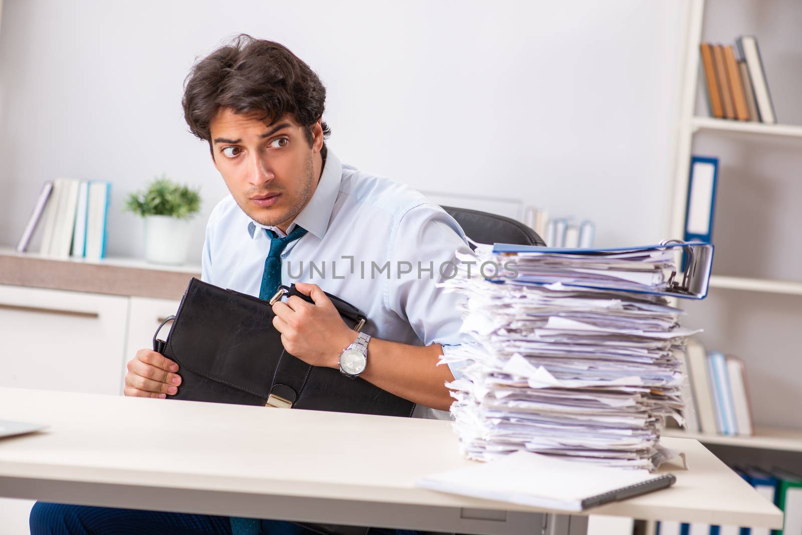 Overloaded busy employee with too much work and paperwork