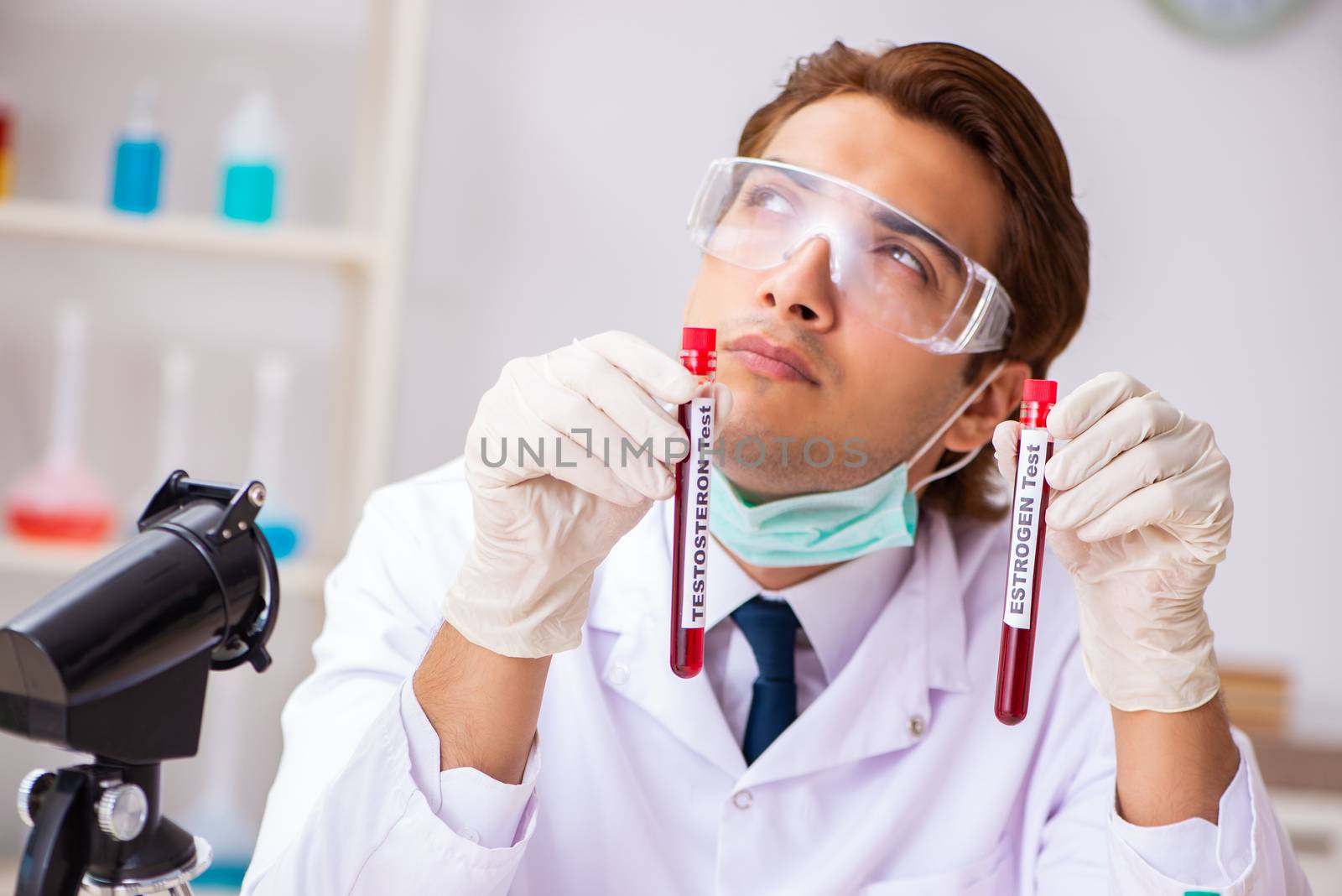 Young handsome lab assistant testing blood samples in hospital 