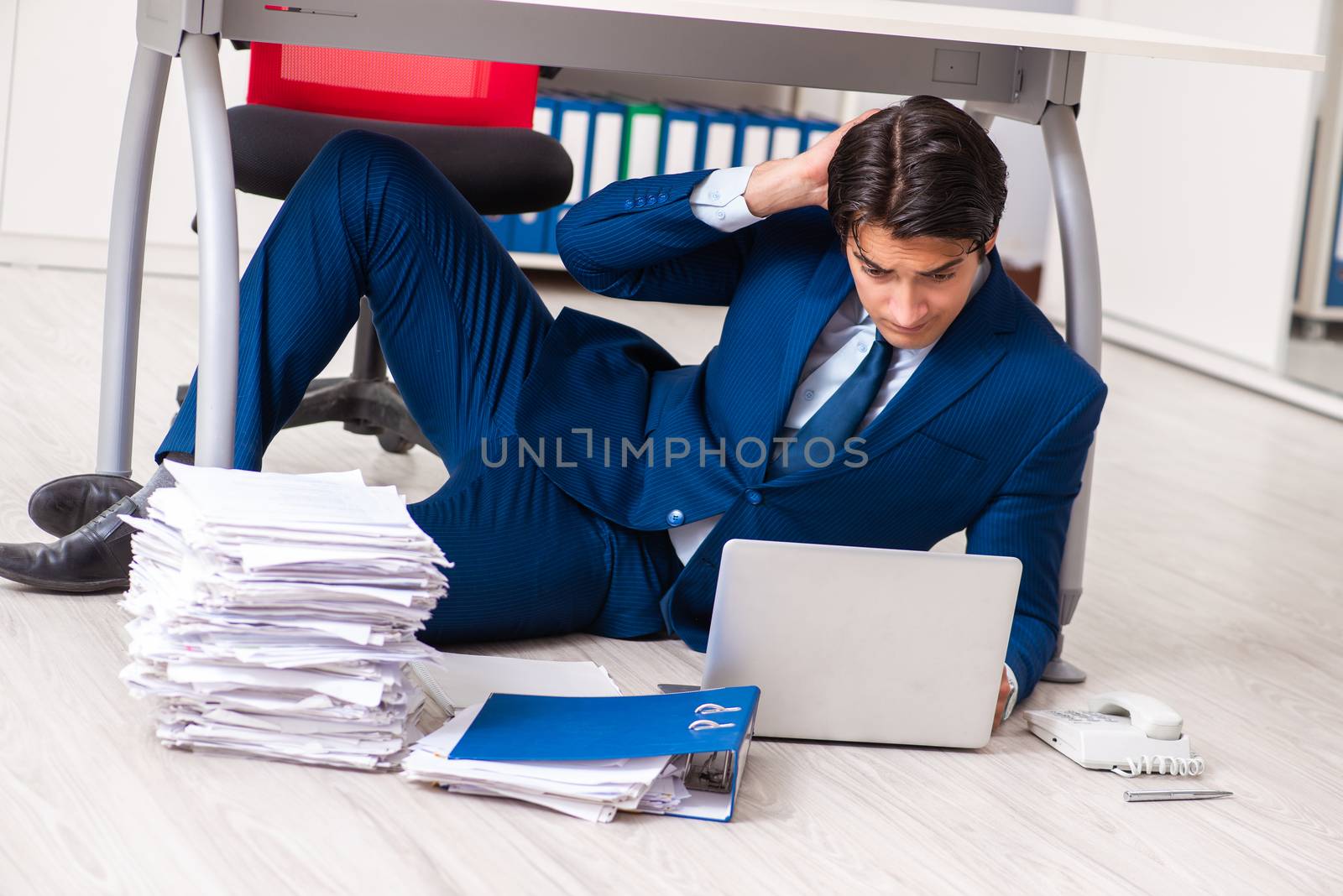 Tired exhausted businessman working overtime in office