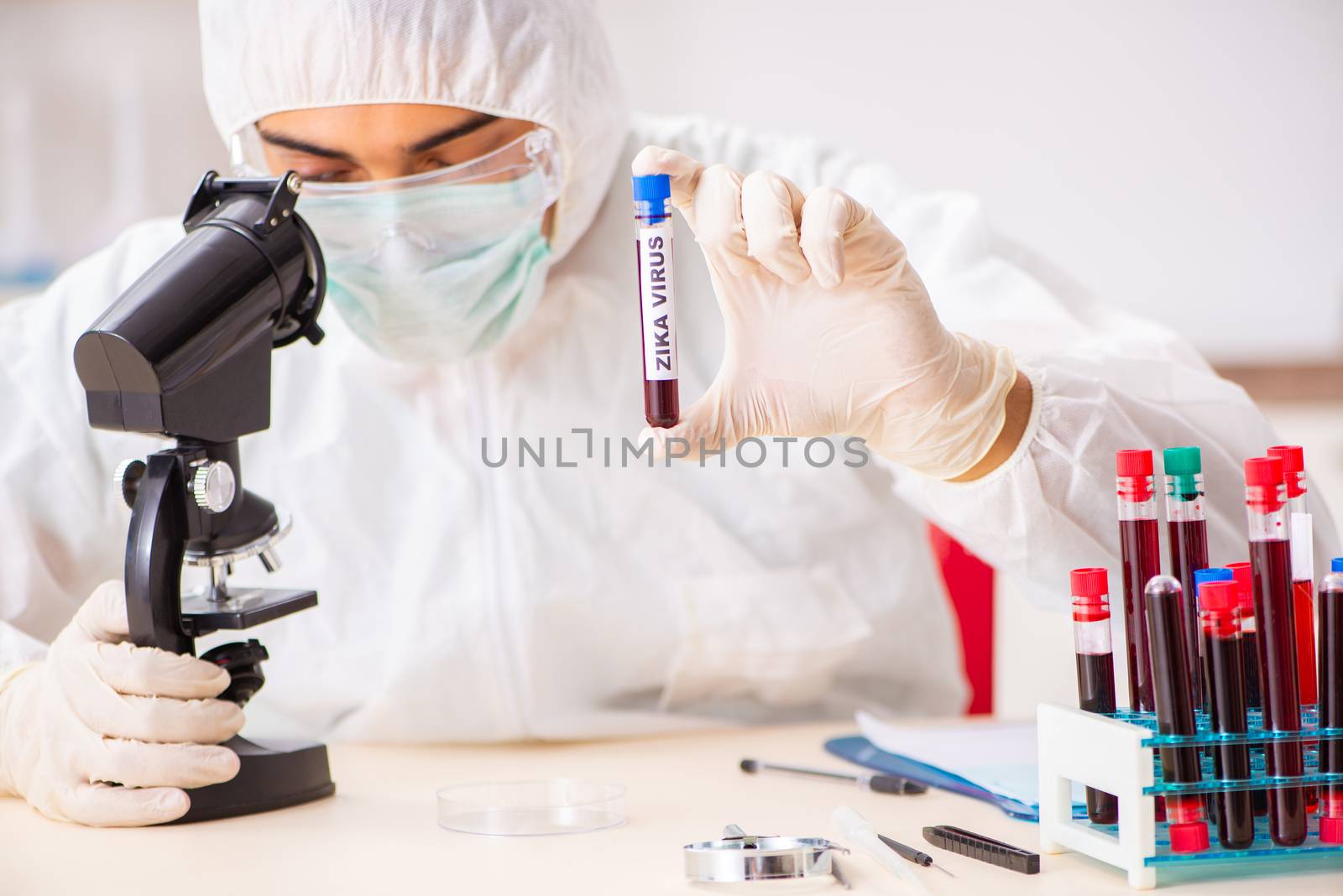 Young handsome lab assistant testing blood samples in hospital 