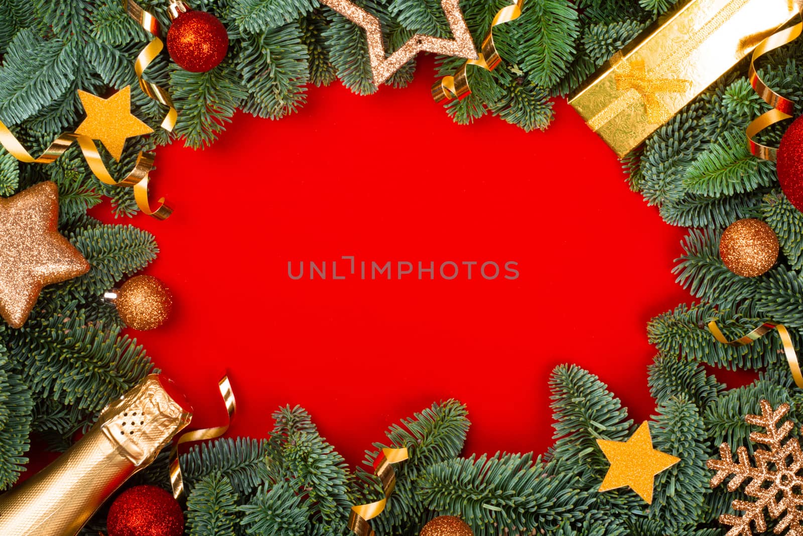 Christmas fir tree branches and baubles decor border frame on red background with copy space for text