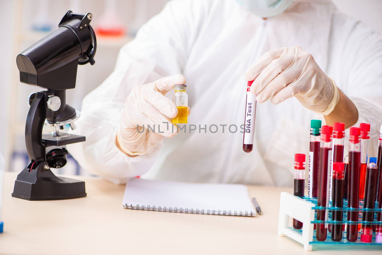 Young handsome lab assistant testing blood samples in hospital 