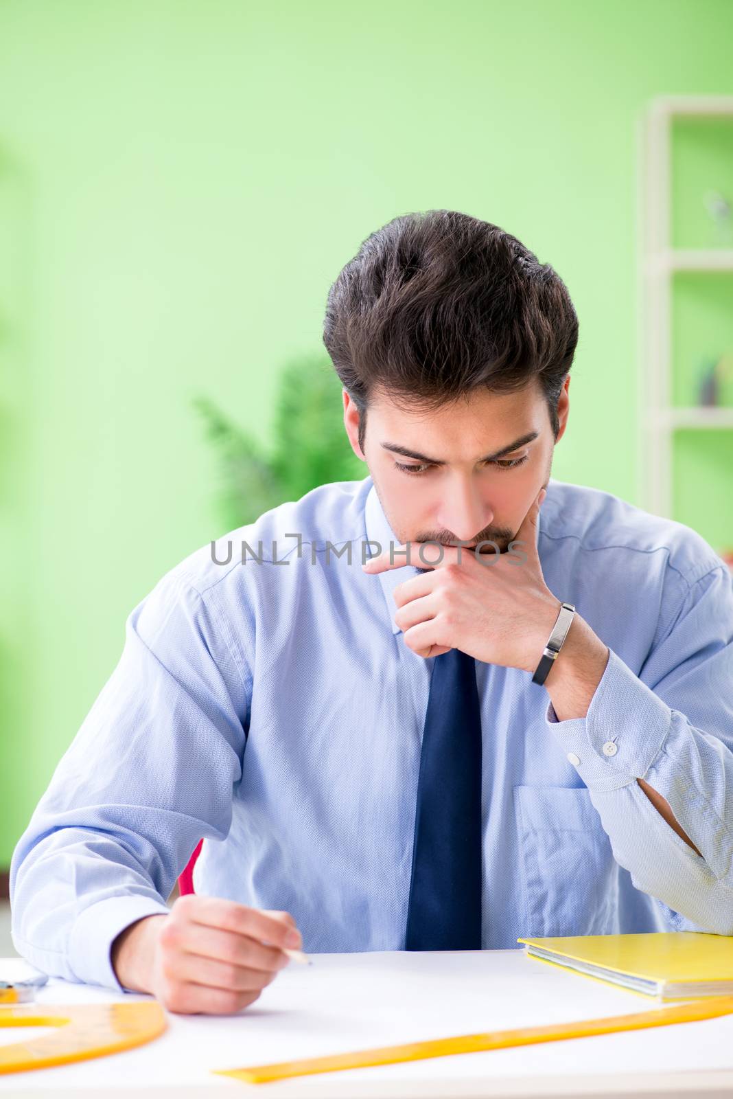 Young male architect working at the project