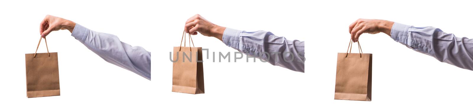 Hand holding shopping bags with christmas shopping on white back by Elnur