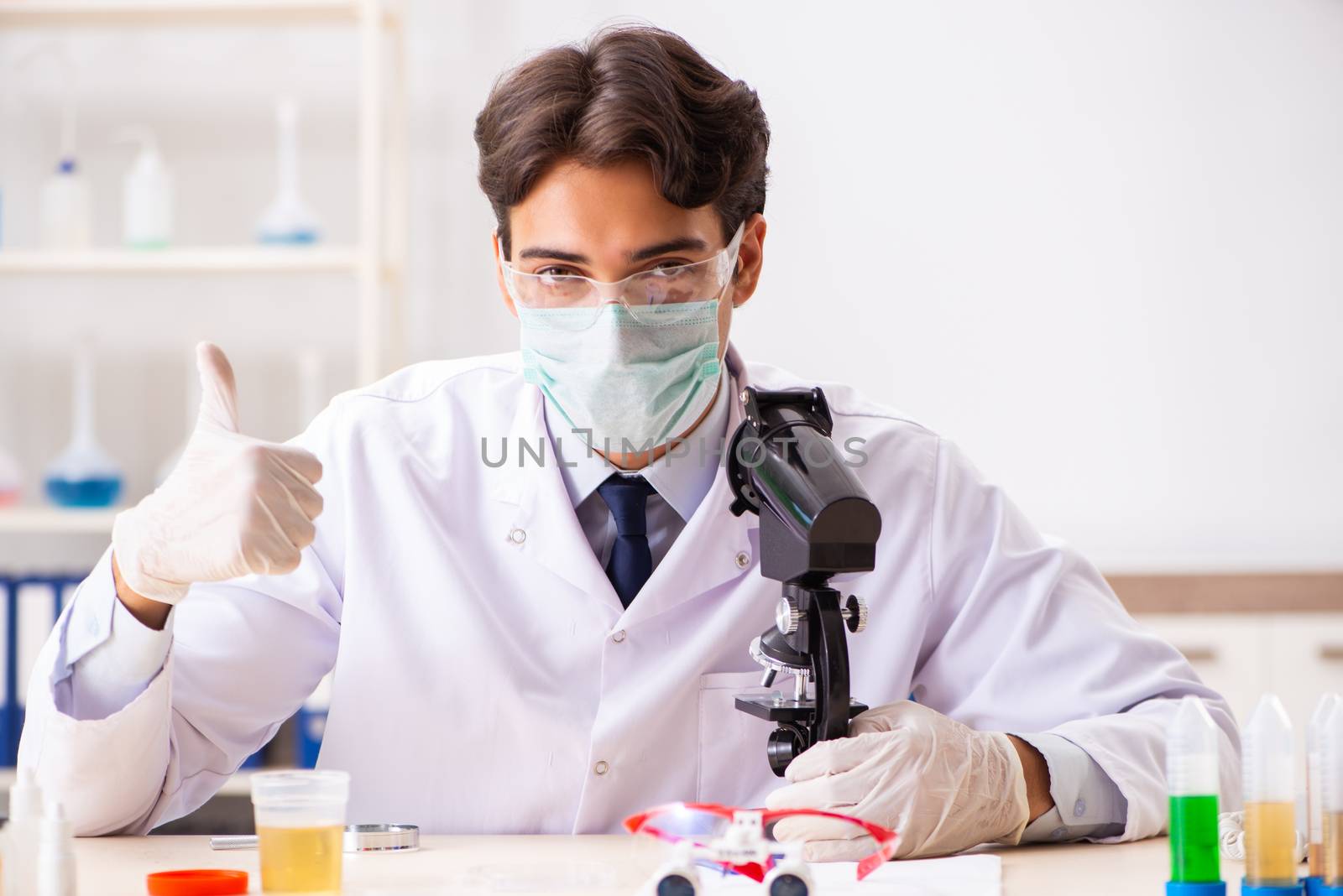 Young handsome chemist working in the lab