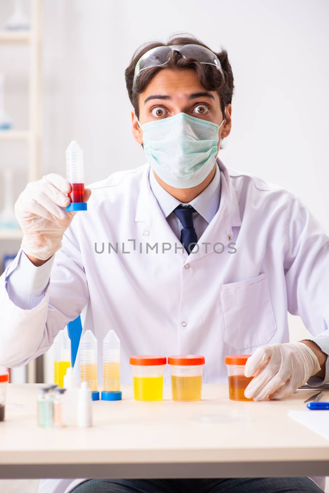 Young handsome chemist working in the lab