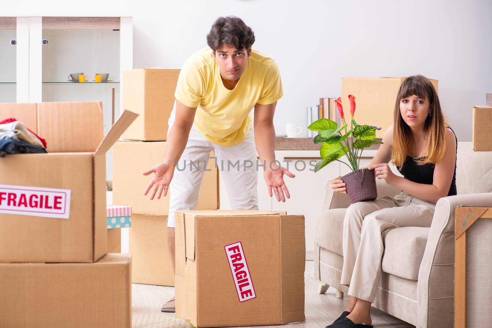 Young couple moving to new flat with fragile things