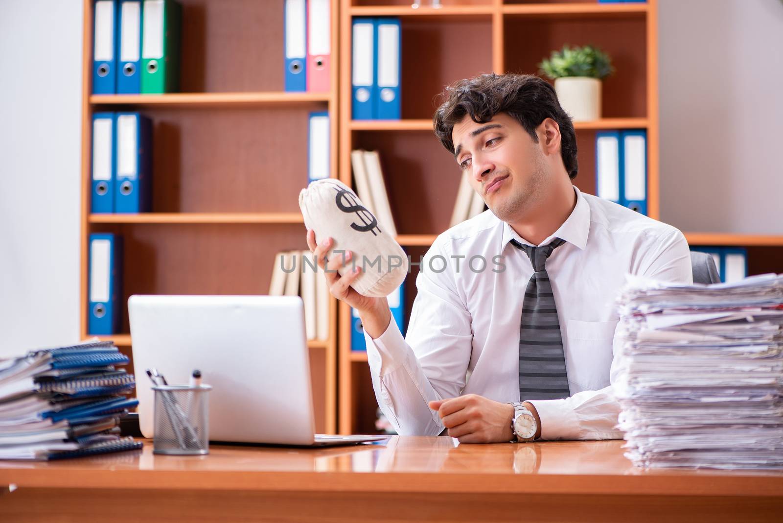 Young handsome businessman unhappy with excessive work 