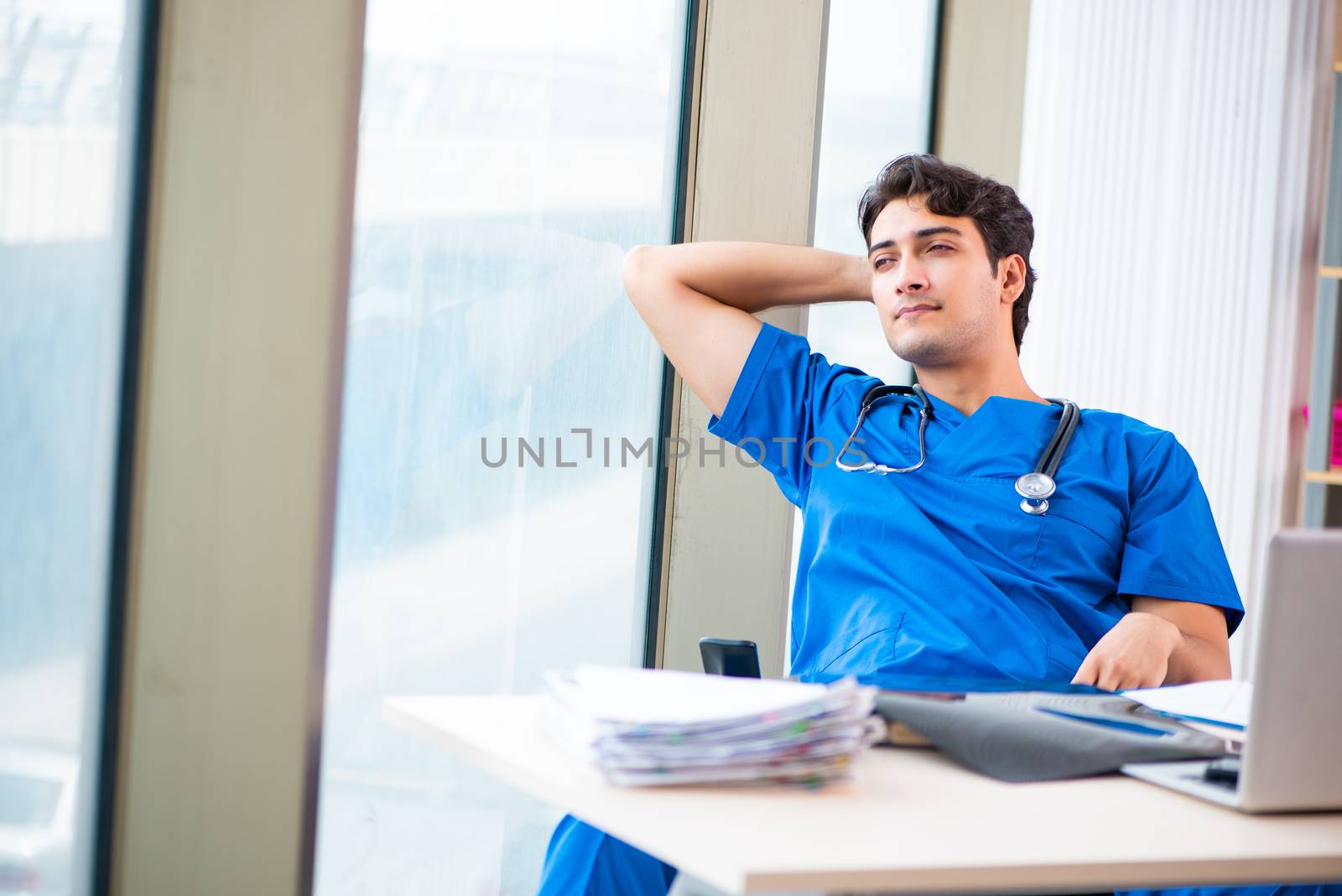 Young handsome doctor working in the hospital 