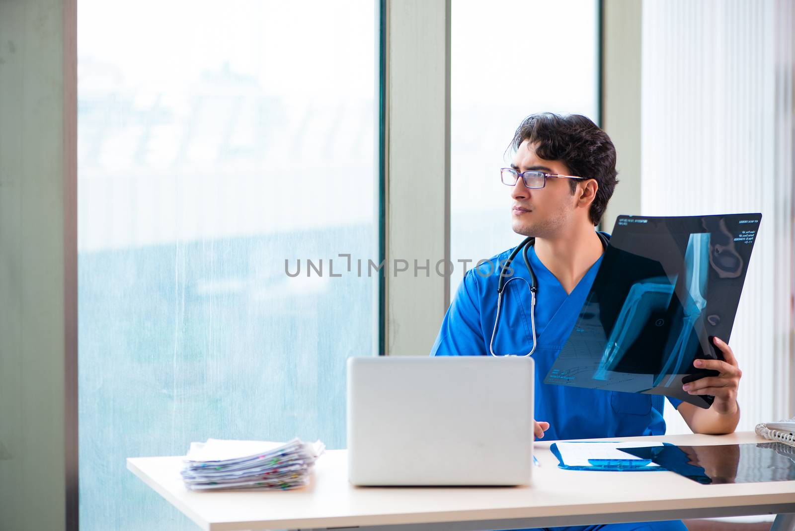 Young handsome doctor working in the hospital 