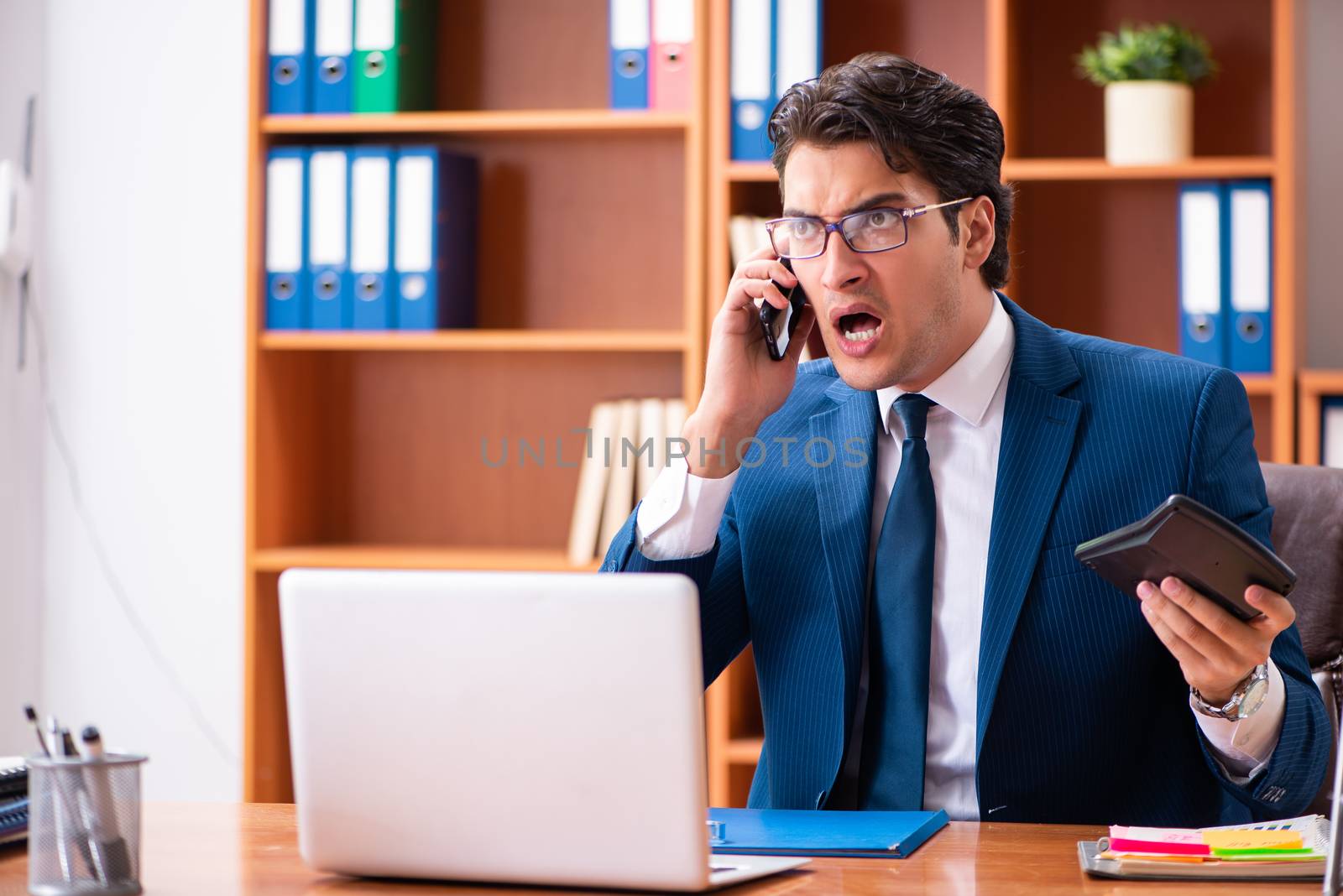 Young handsome businessman working in the office