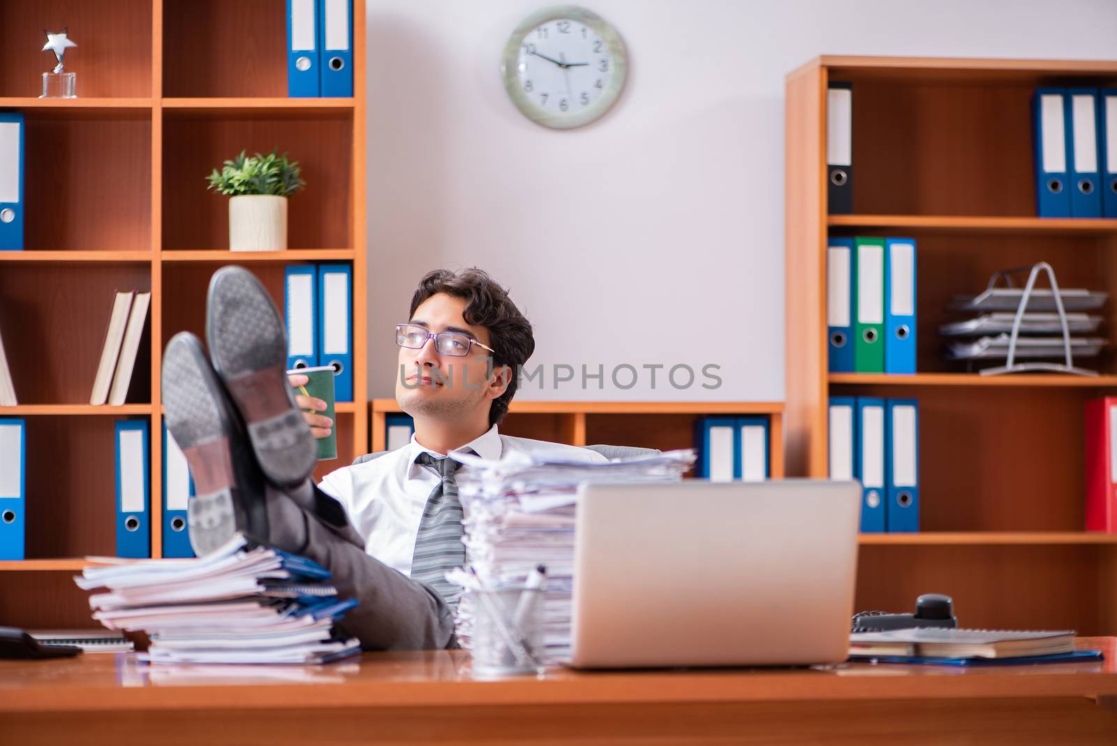 Young handsome businessman unhappy with excessive work 