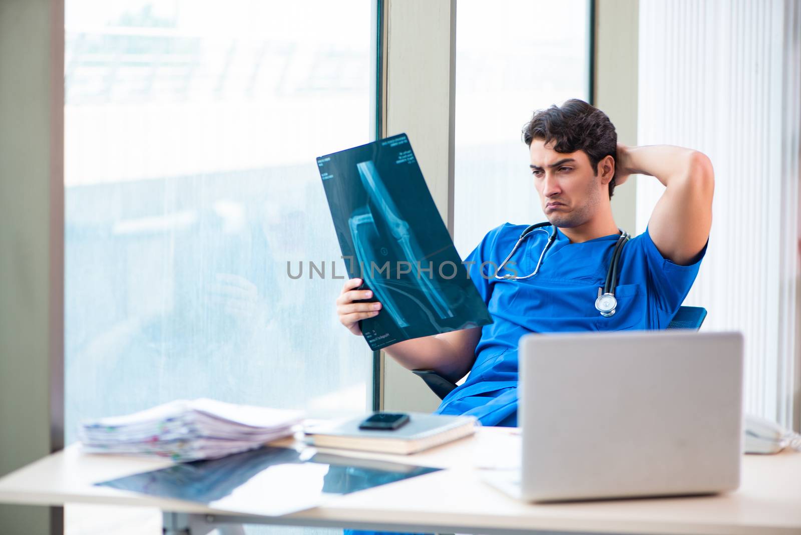 Young handsome doctor working in the hospital 