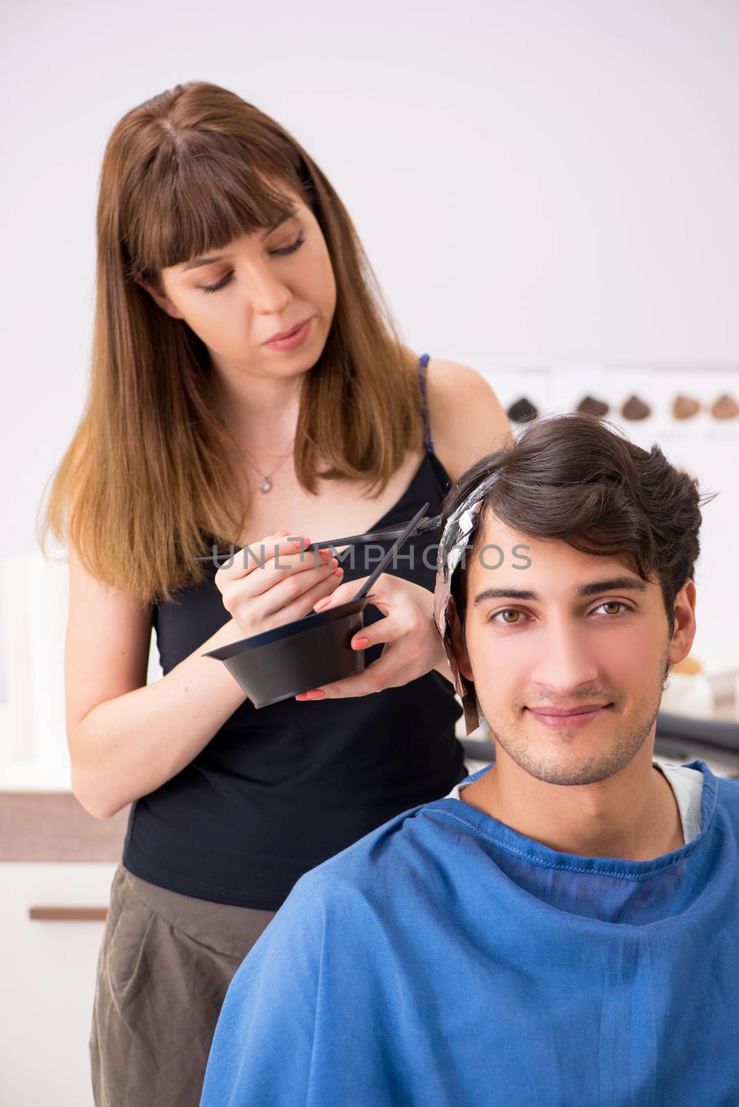 Young attracrive man visiting female barber 