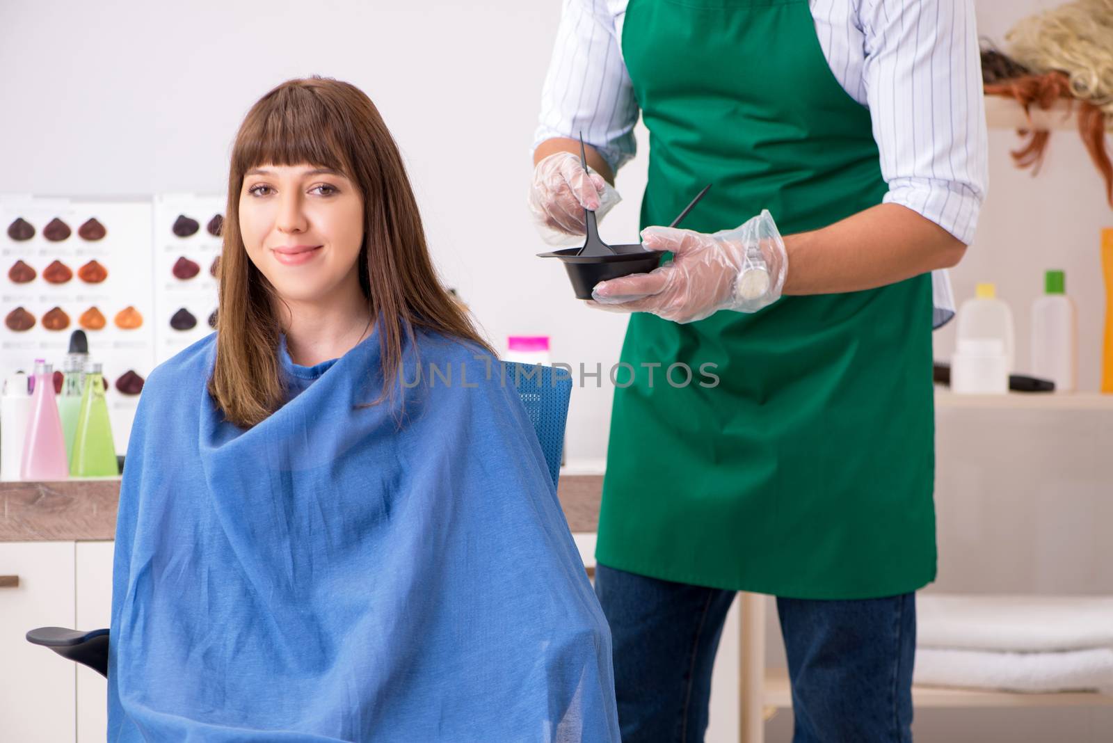 Young woman visiting young handsome barber 