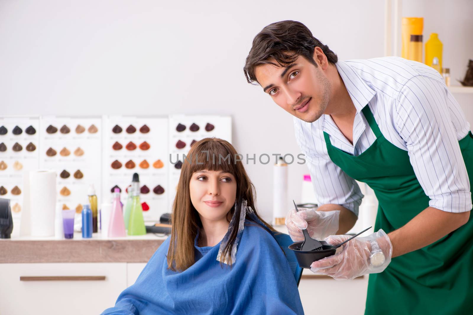 Young woman visiting young handsome barber 