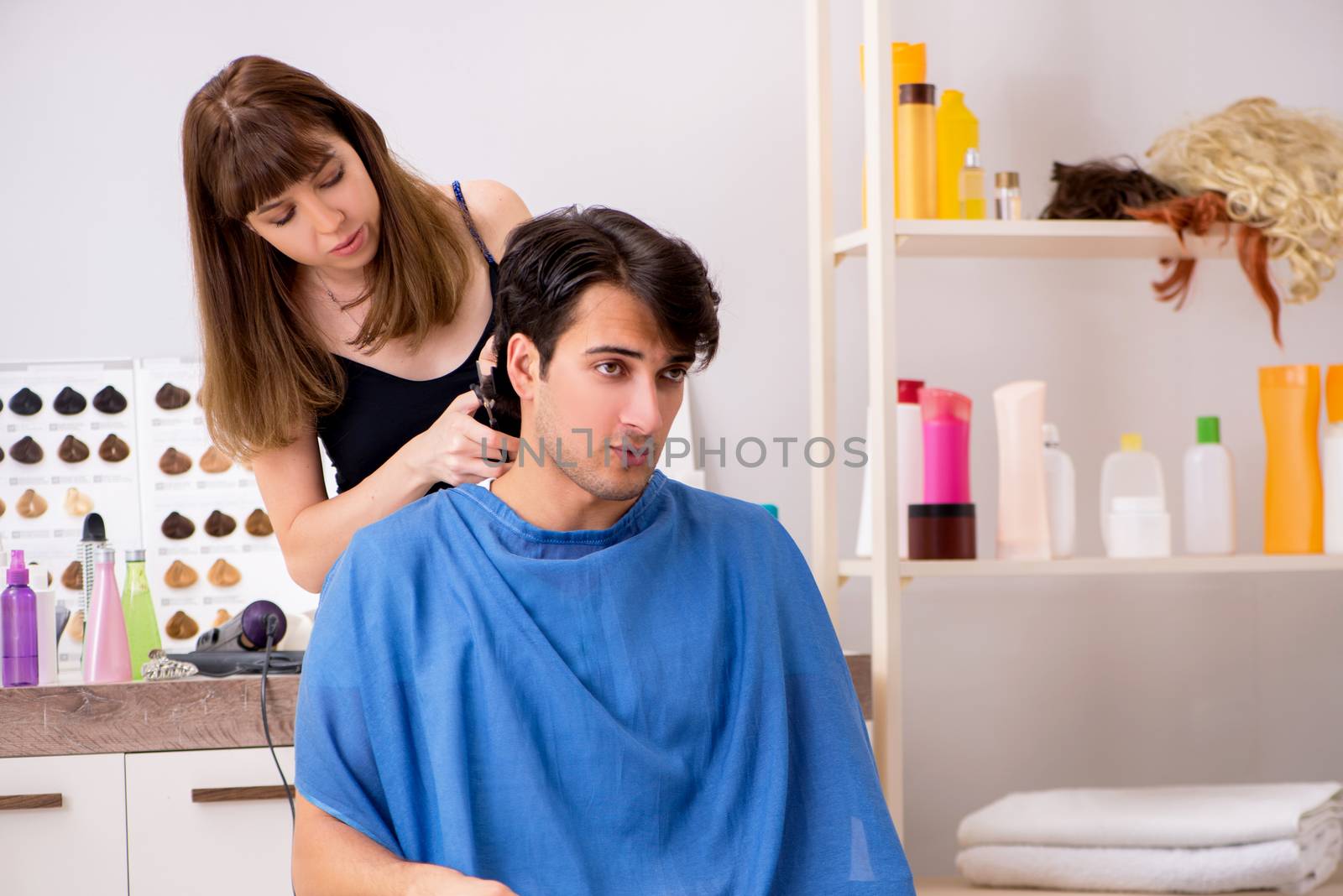 Young attracrive man visiting female barber  by Elnur