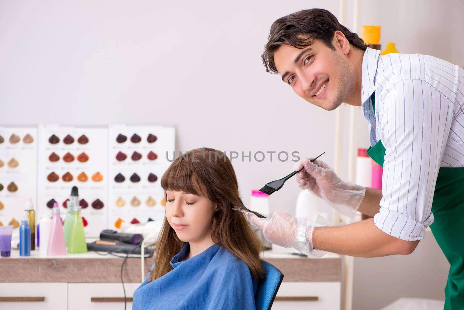 Young woman visiting young handsome barber 