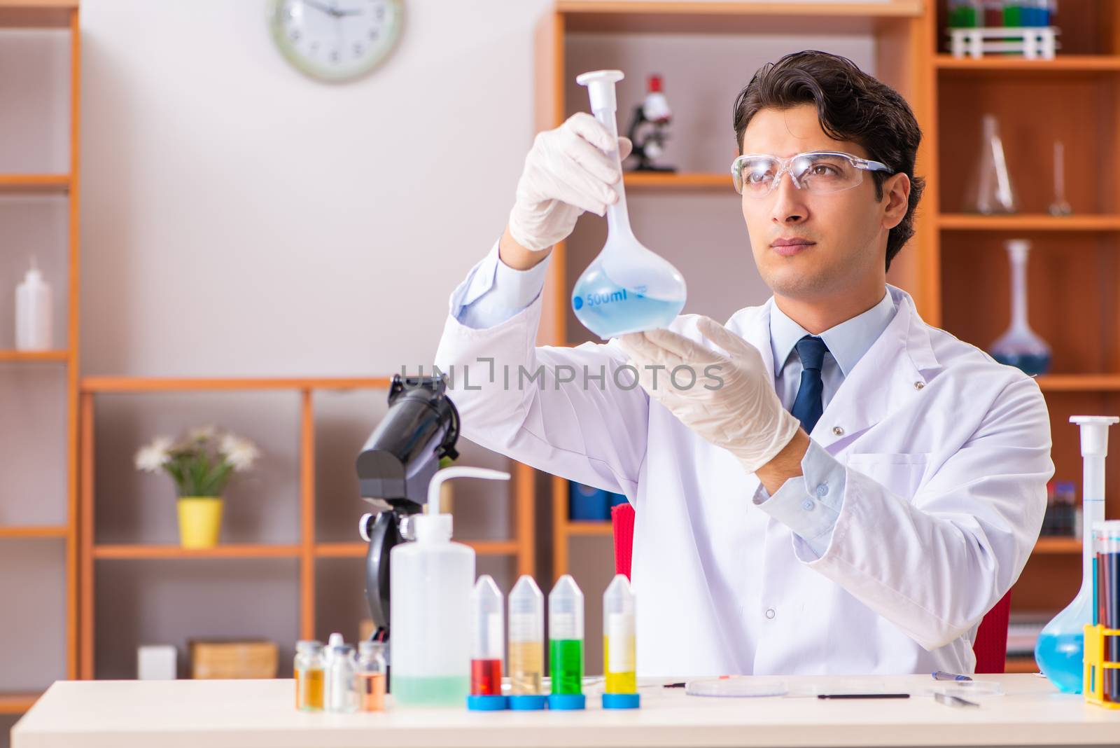 Young handsome biochemist working in the lab 