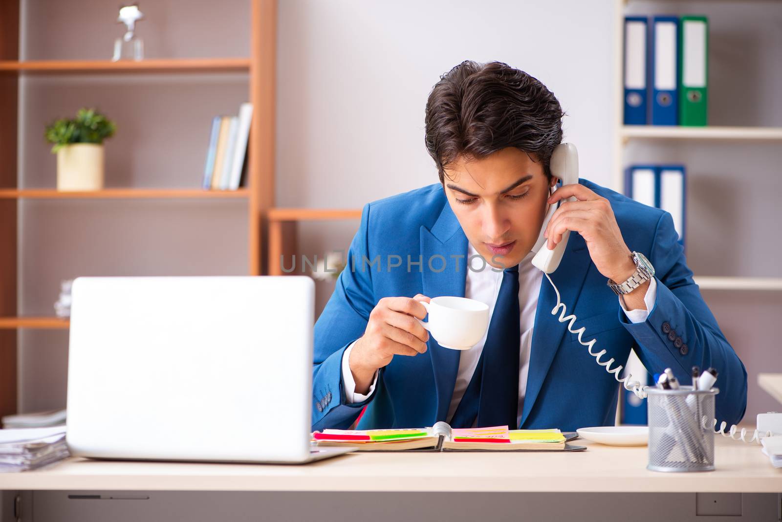Young handsome businessman working in the office  by Elnur