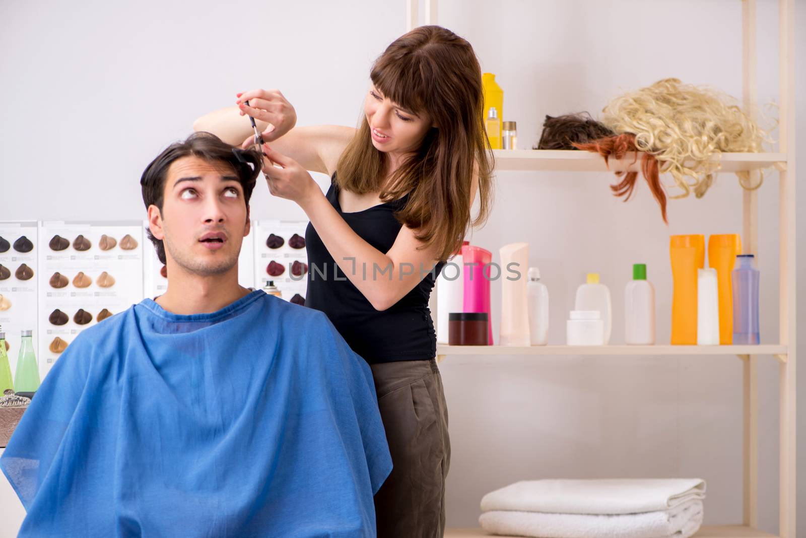 Young attracrive man visiting female barber 