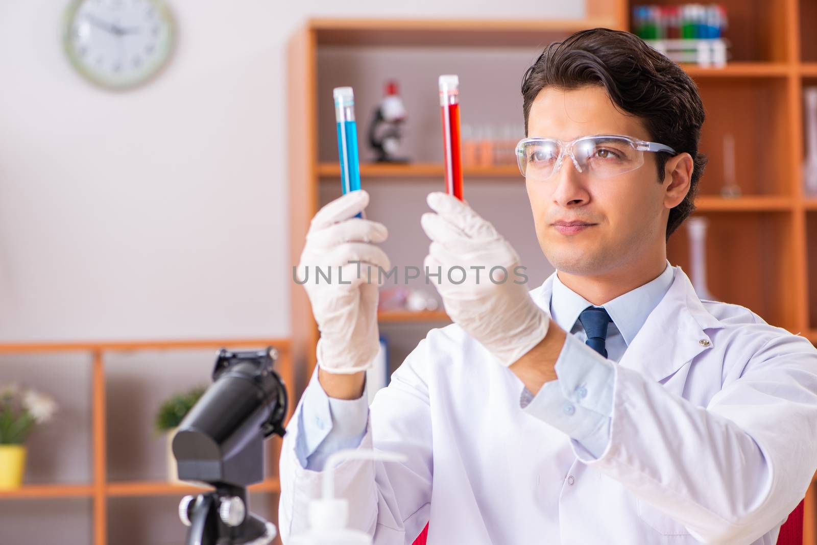 Young handsome biochemist working in the lab  