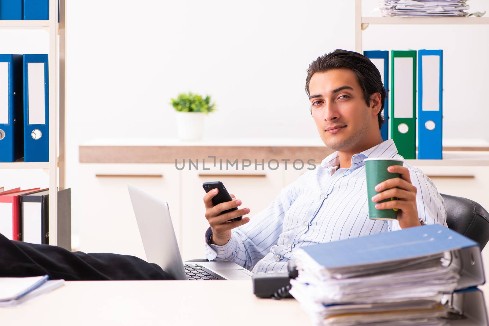 Young employee sitting at the office  by Elnur