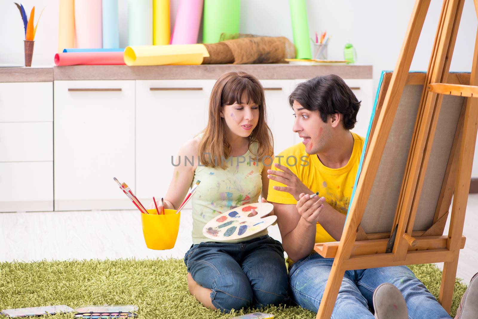 Young couple enjoying painting at home by Elnur