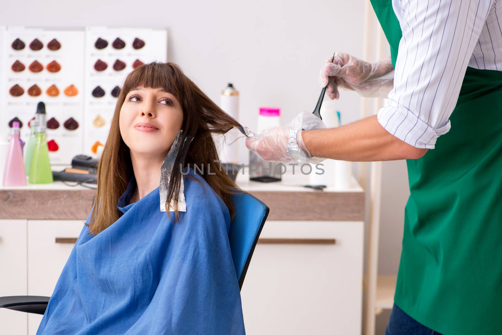 Young woman visiting young handsome barber 