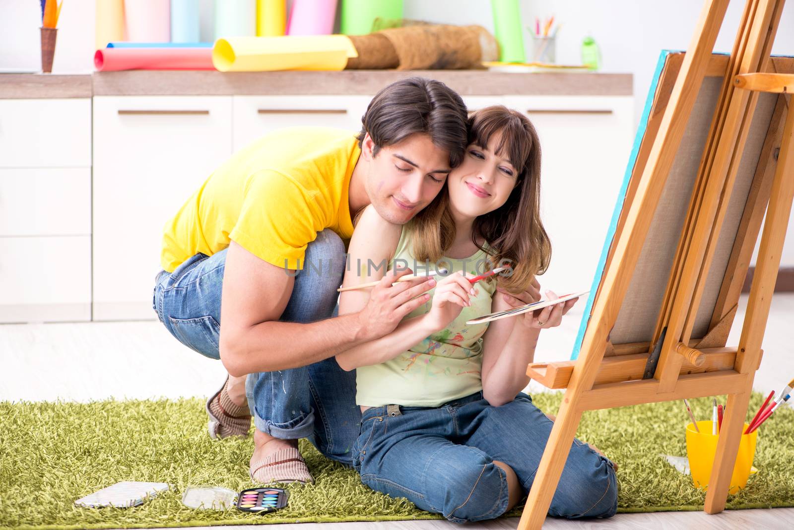 Young couple enjoying painting at home by Elnur