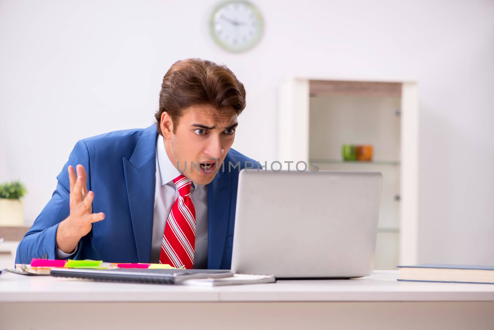 Young attractive businessman working in the office  