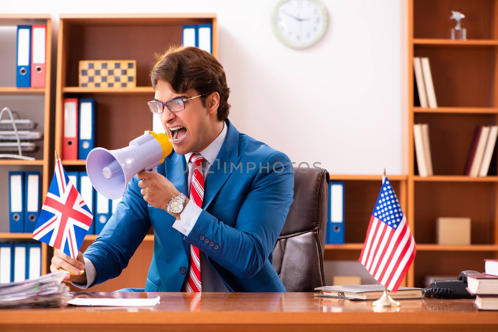 Young handsome politician sitting in office 