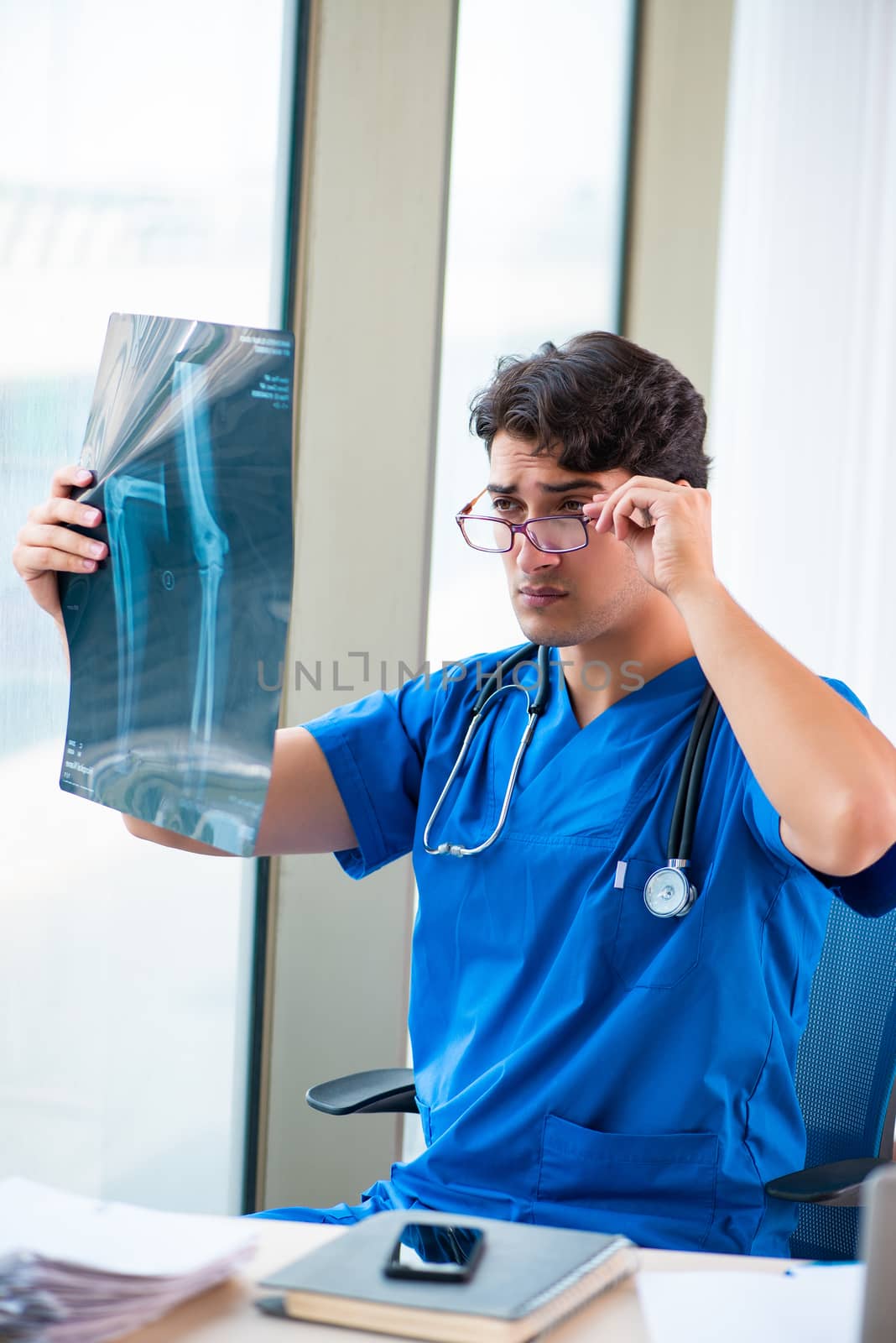 Young handsome doctor working in the hospital 