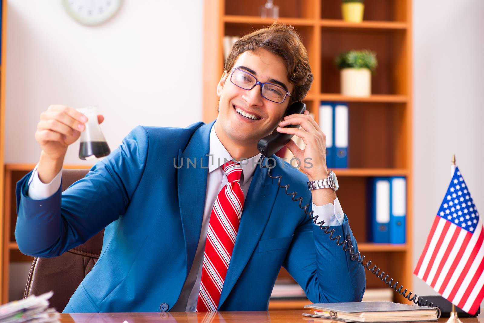 Young handsome politician sitting in office 