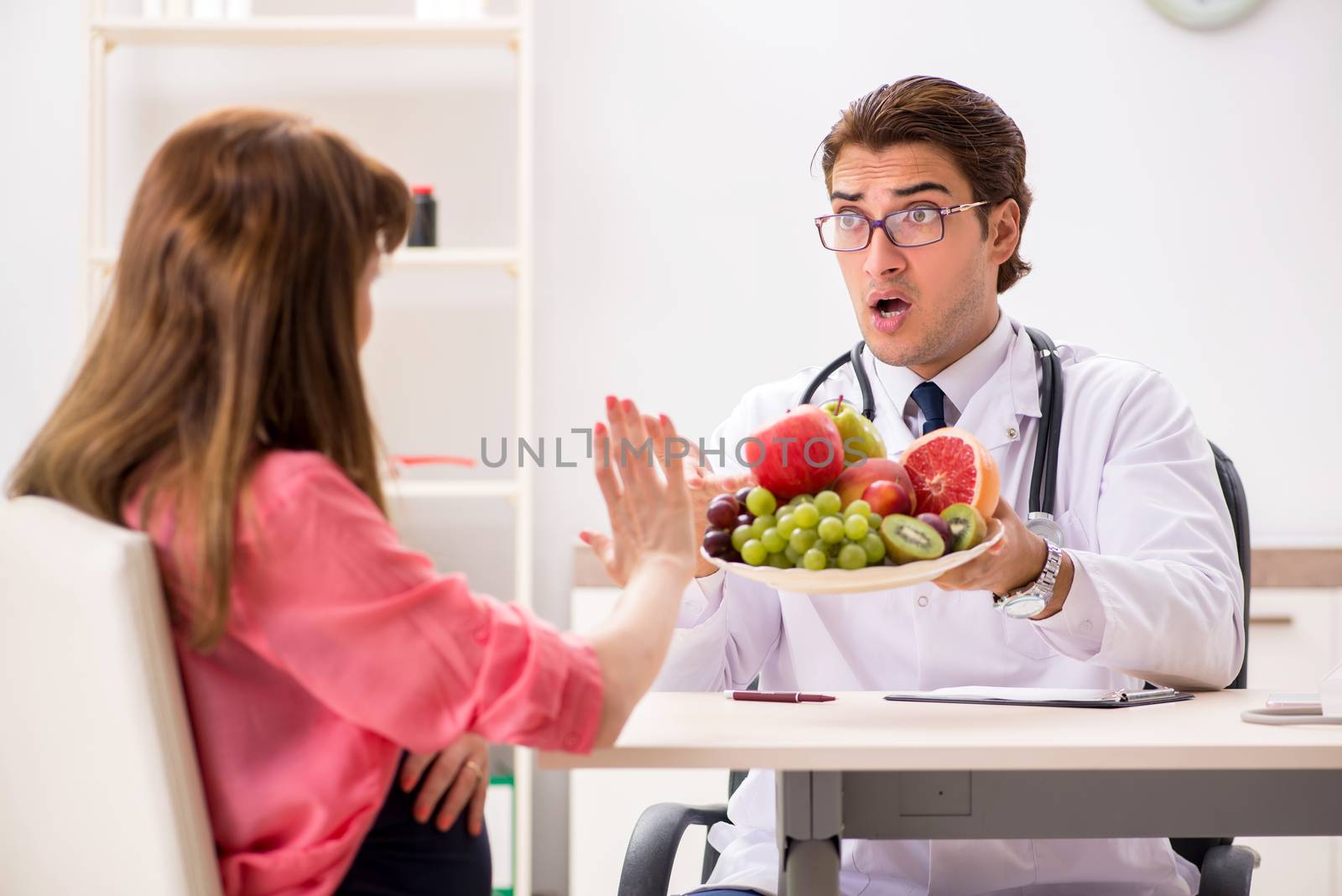 Pregnant woman visiting doctor discussing healthy diet