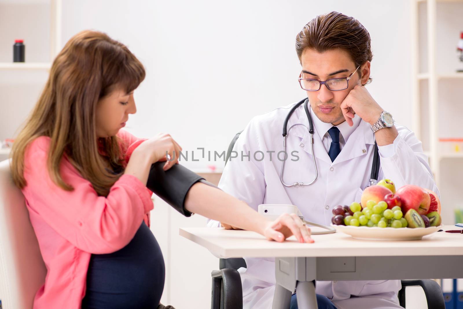 Pregnant woman visiting doctor discussing healthy diet