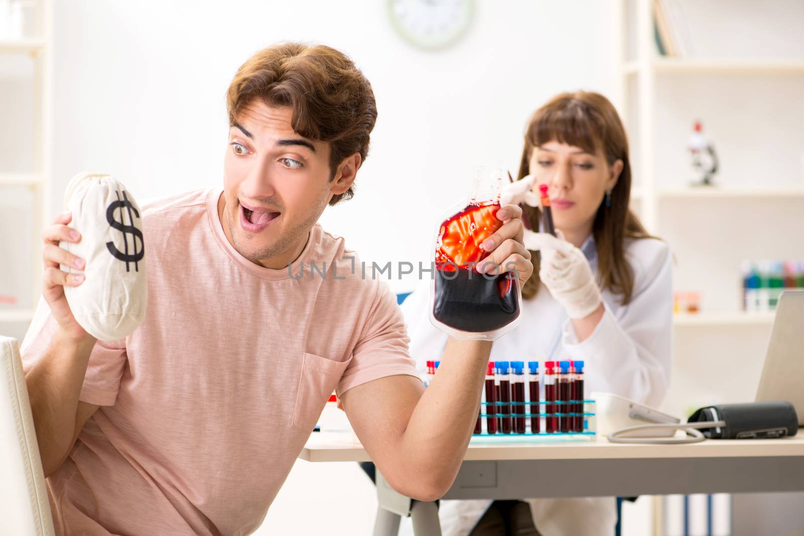 Man giving his blood as a donor by Elnur