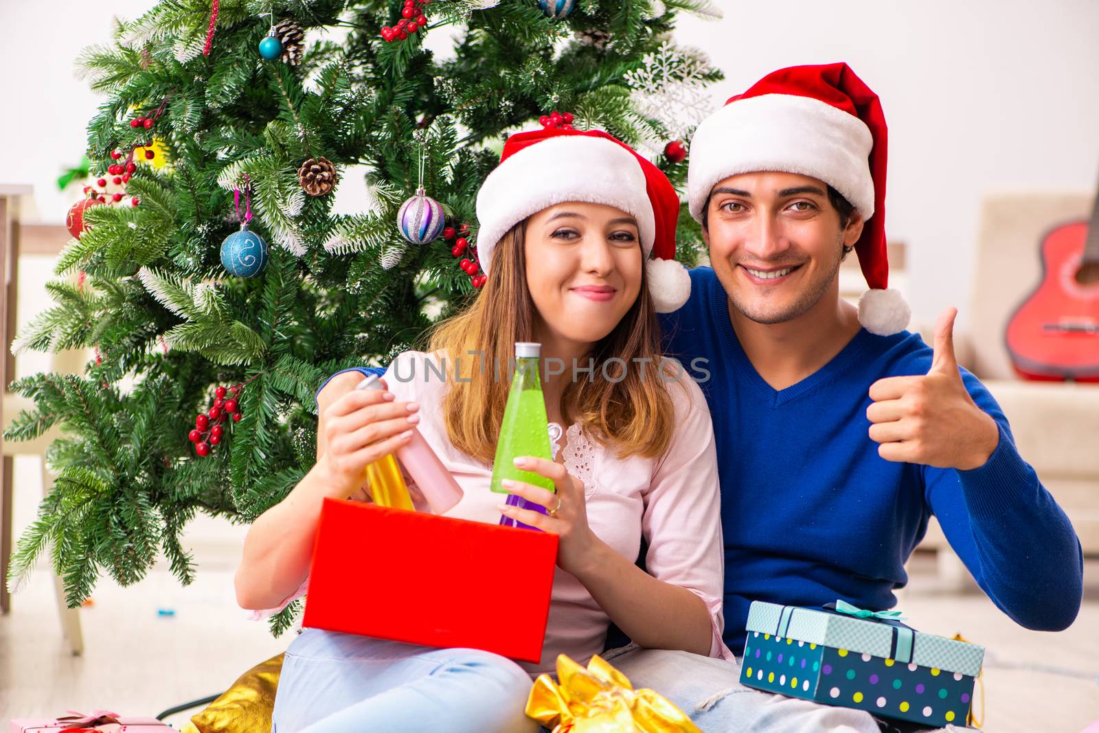 Young couple celebrating christmas at home by Elnur