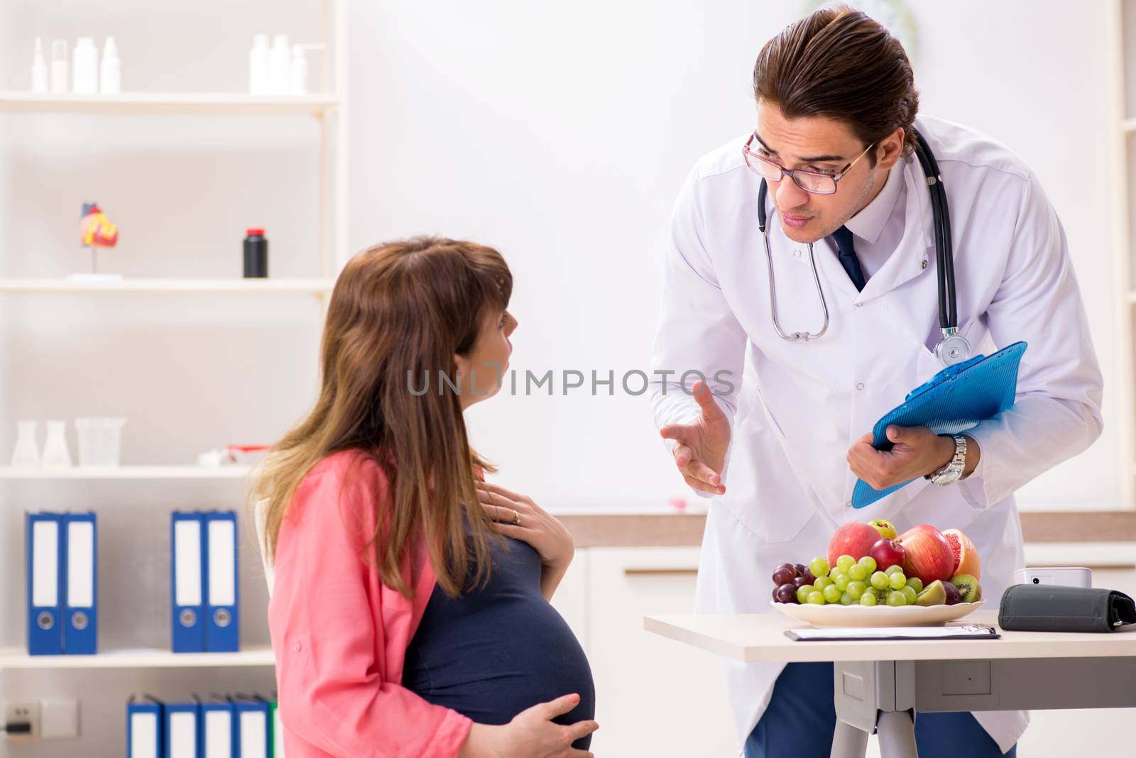 Pregnant woman visiting doctor discussing healthy diet