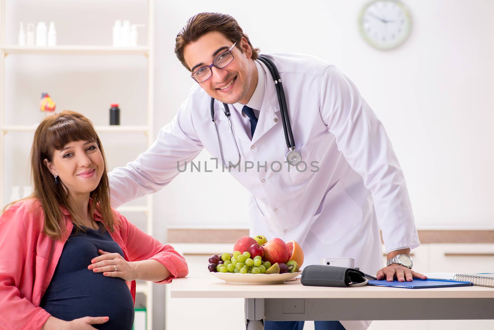 Pregnant woman visiting doctor discussing healthy diet